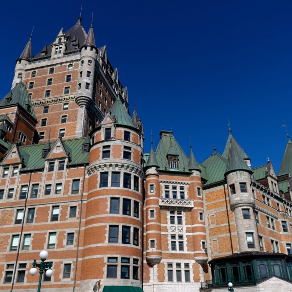 a castle on top of a tall building with Château Frontenac in the background