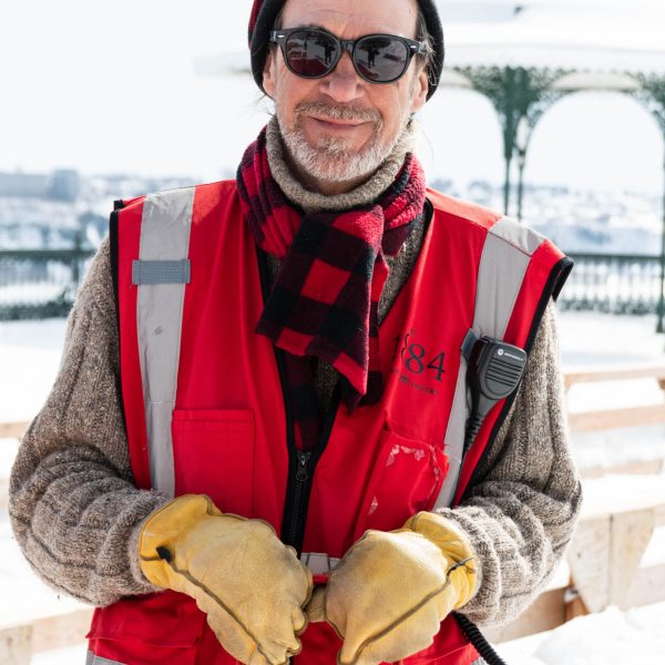 a man wearing a hat and sunglasses posing for the camera