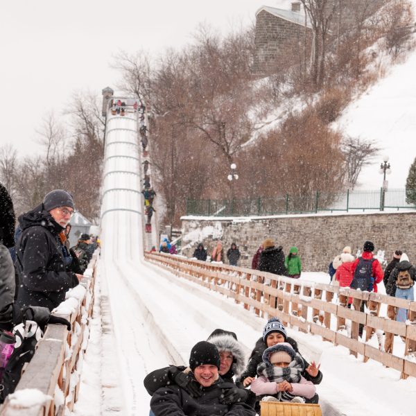 a group of people sitting on a bench in the snow
