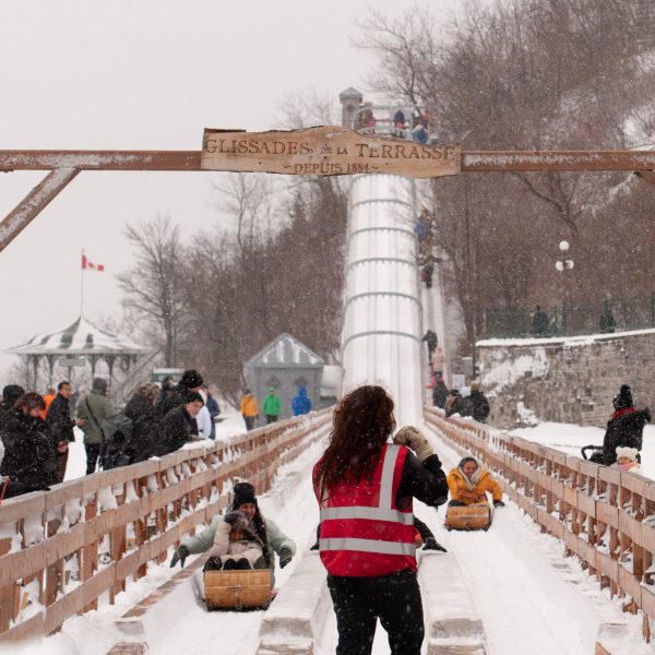 a group of people riding skis across snow covered ground