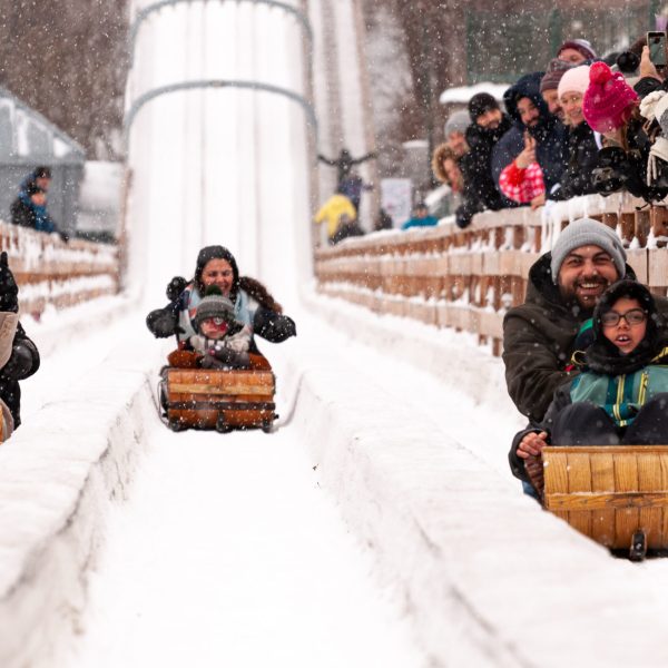 a group of people sitting around a pile of snow