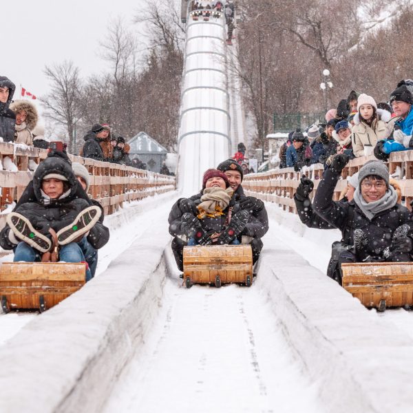 a group of people sitting on a bench next to a pile of snow