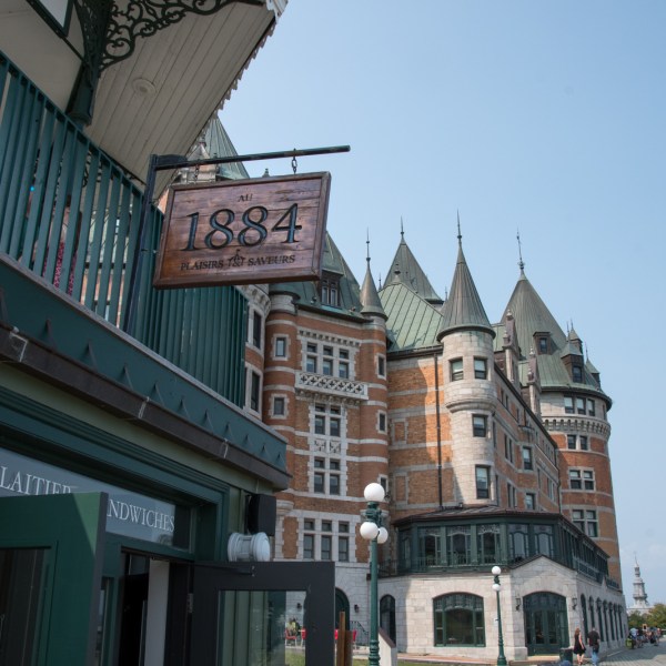 a large brick building with a clock on the side of the street
