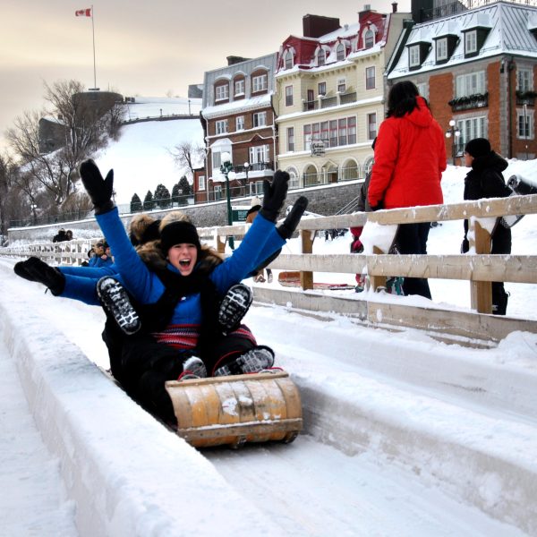 a man doing a trick on a bench in the snow