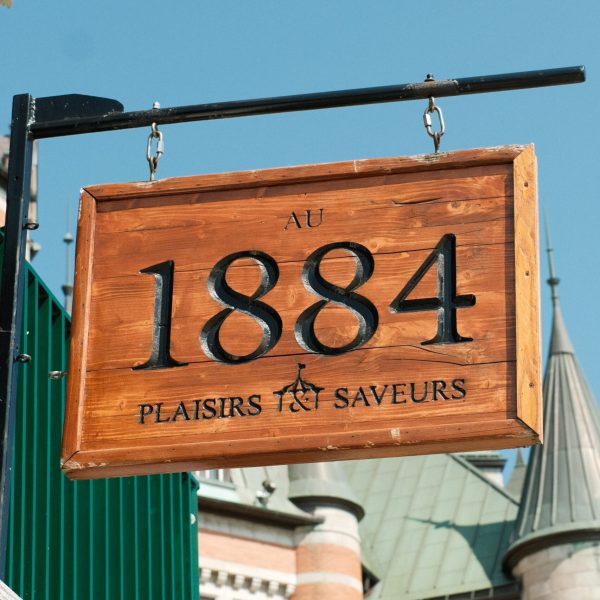 a sign hanging off the side of a building