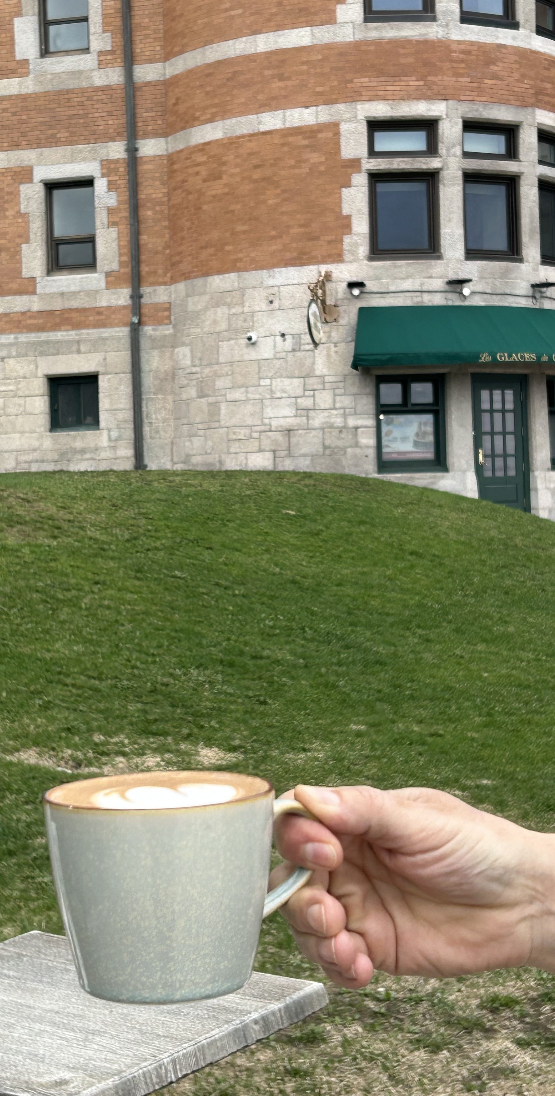 a person sitting in front of a brick building