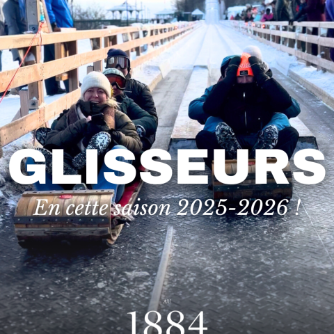 People sledding down a snowy track with winter clothing and helmets.