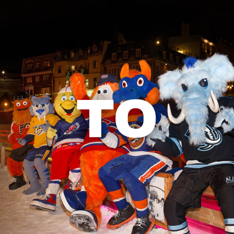 Six sports mascots sitting on a bench outdoors at night.